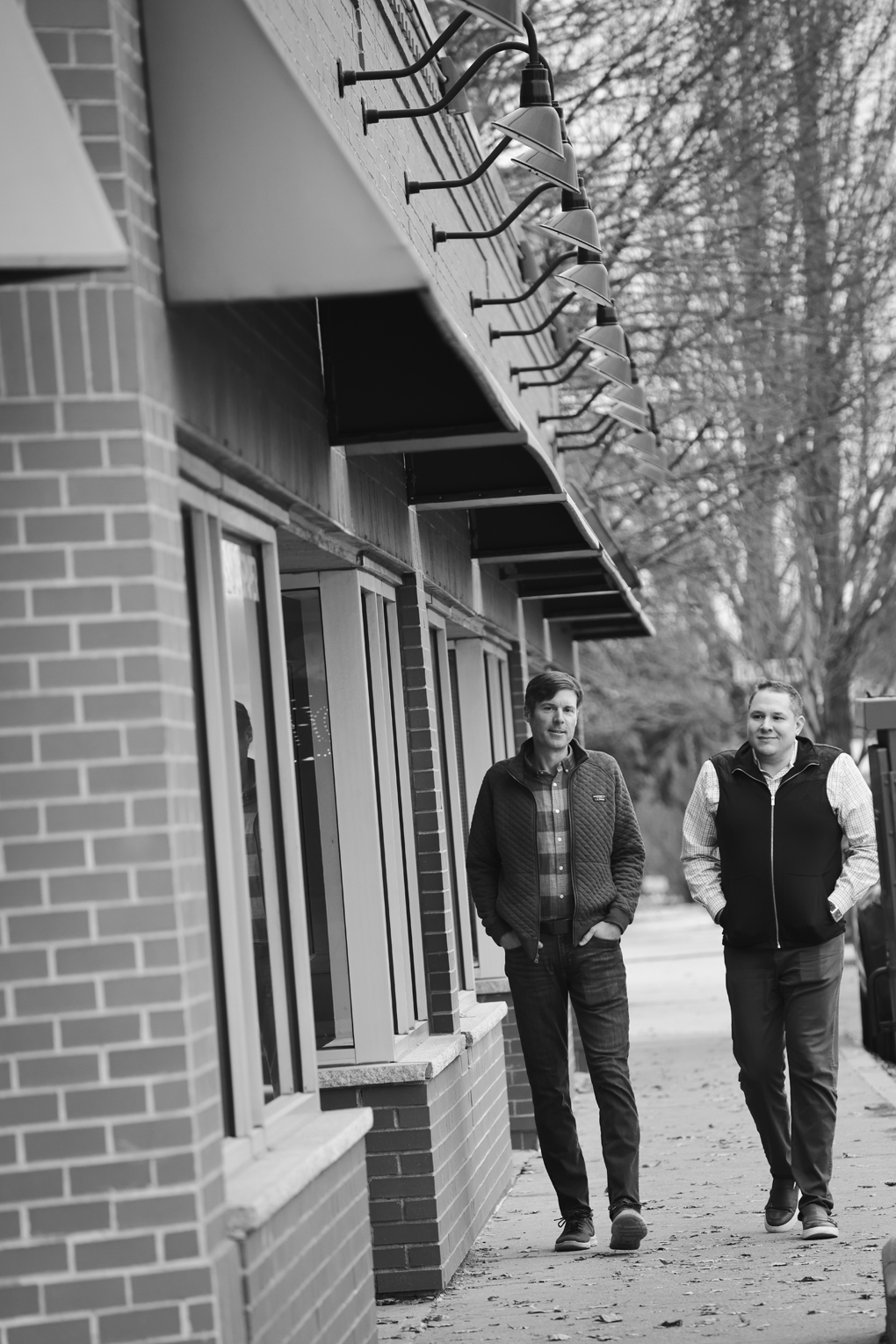 Black and white photo of Ryan Gorman and Brian Iammartino walking down a street, towards the camera